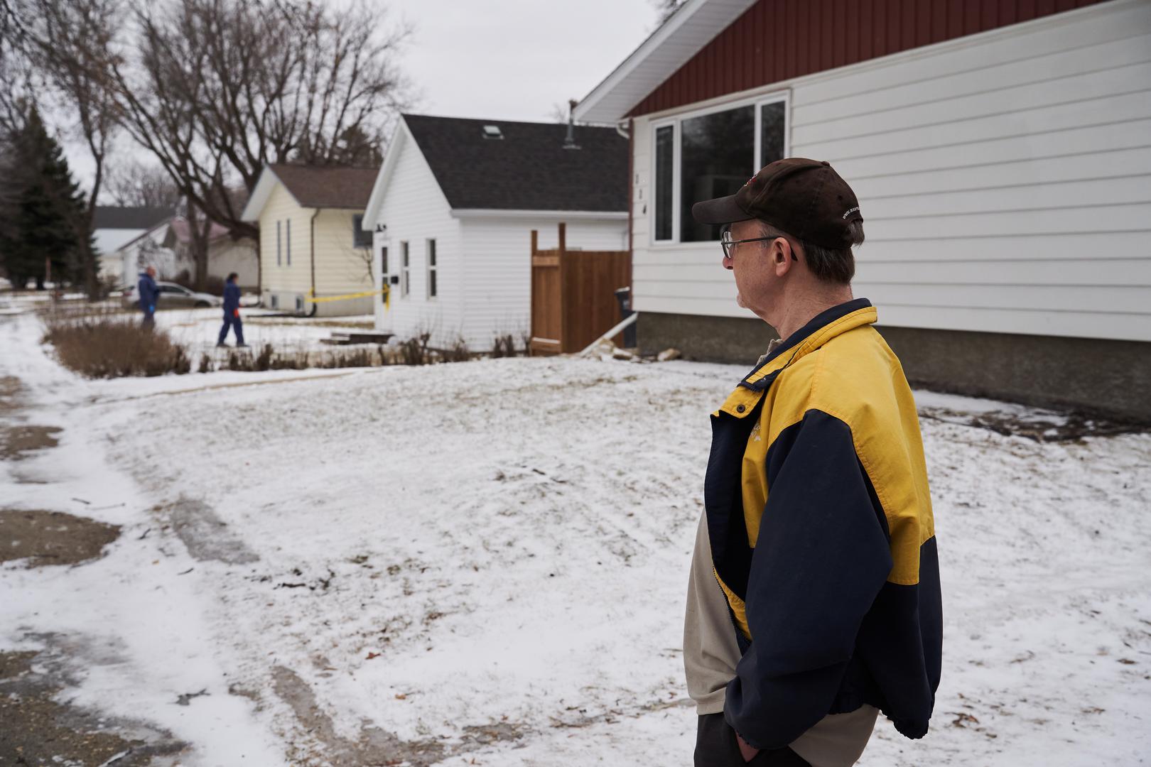 Neighbour Randy McFarlane looks over at the scene of an ongoing investigation regarding five deaths in southern Manitoba, in Carman, Man., Monday, Feb. 12, 2024. THE CANADIAN PRESS/David Lipnowski