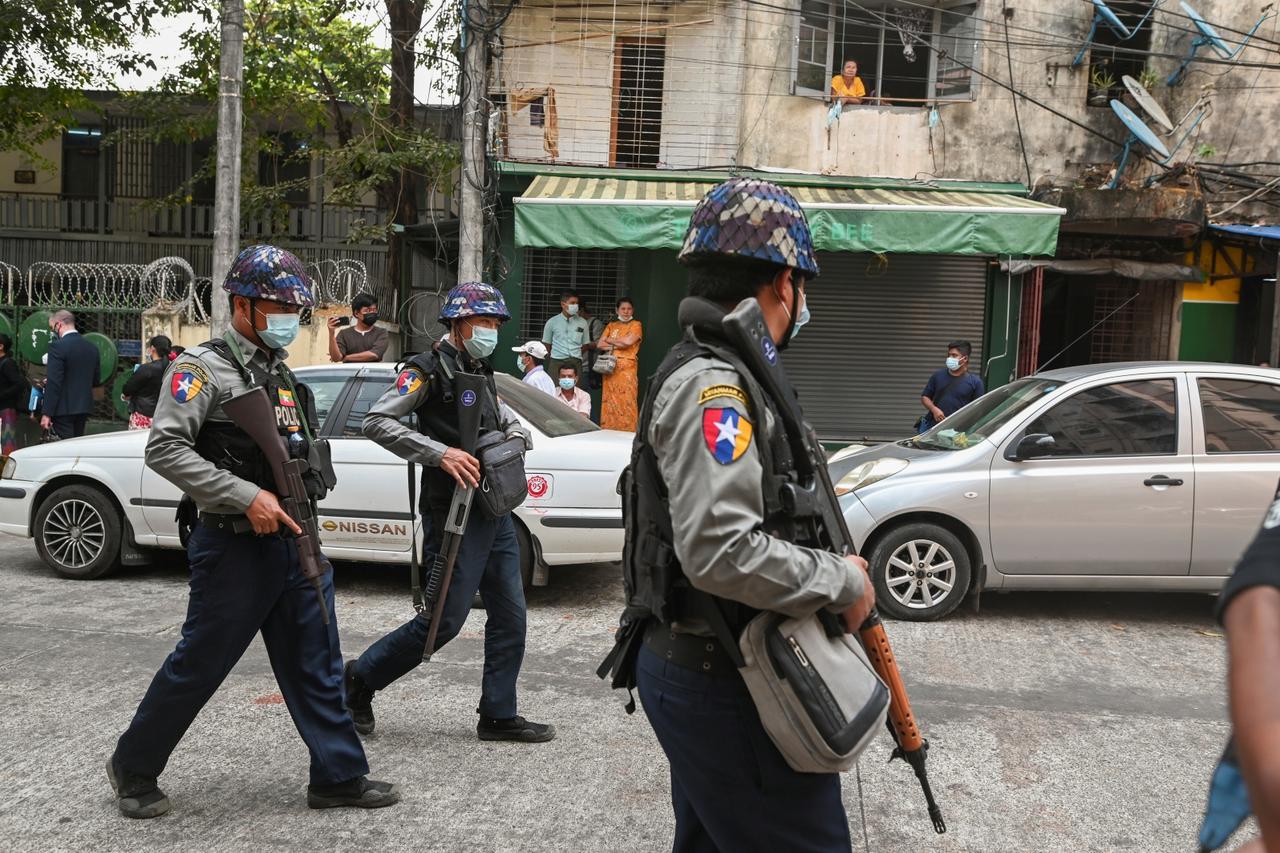 Police officers walk outside Kamayut township court where the hearing of a group of journalists who were detained during anti-coup protests is scheduled, including that of Associated Press journalist Thein Zaw, in Yangon