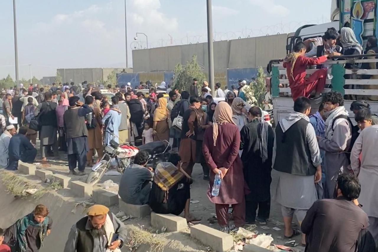 People wait outside Kabul airport, in Kabul