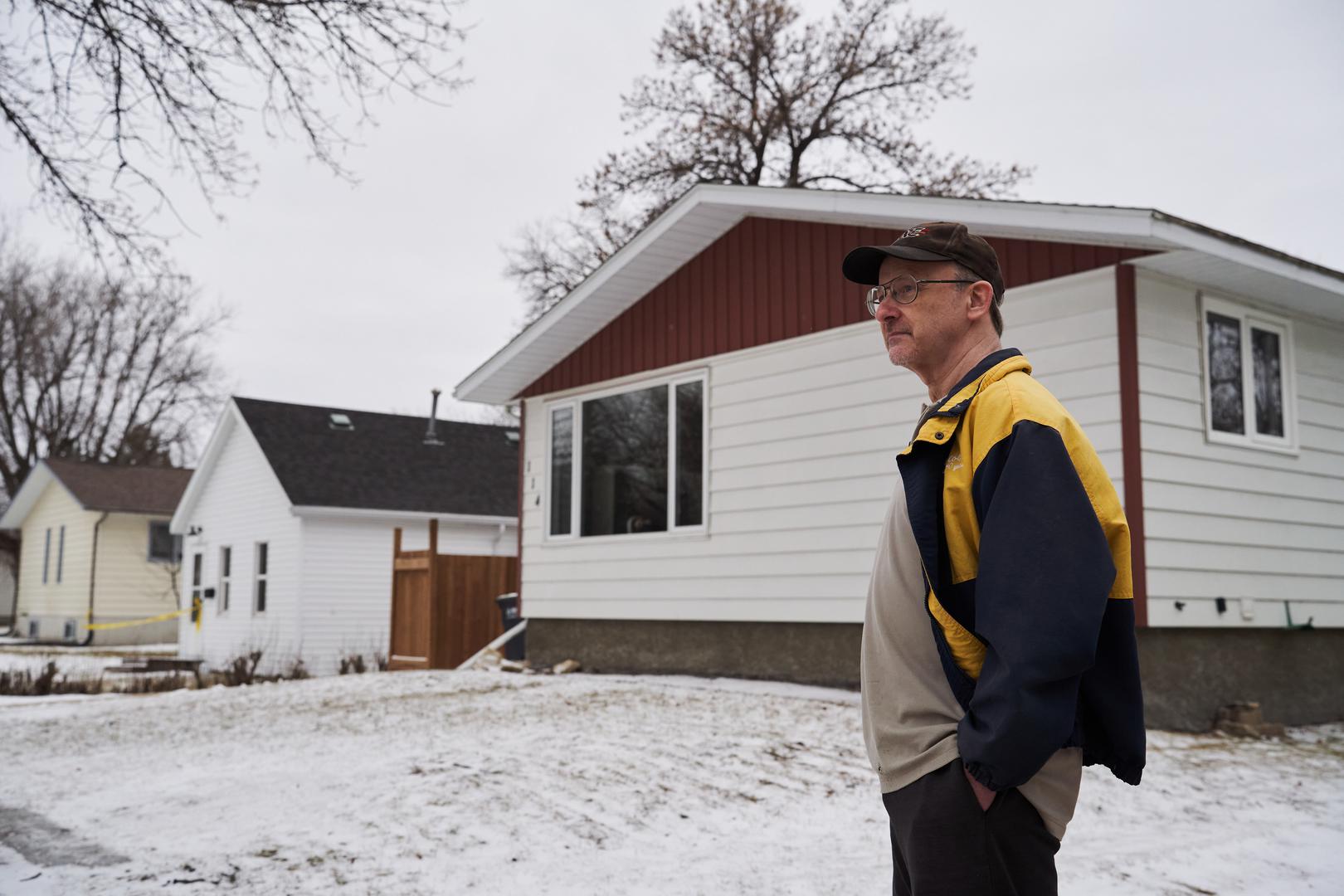 Neighbour Randy McFarlane looks over at the scene of an ongoing investigation regarding five deaths in southern Manitoba, in Carman, Man., Monday, Feb. 12, 2024. THE CANADIAN PRESS/David Lipnowski
