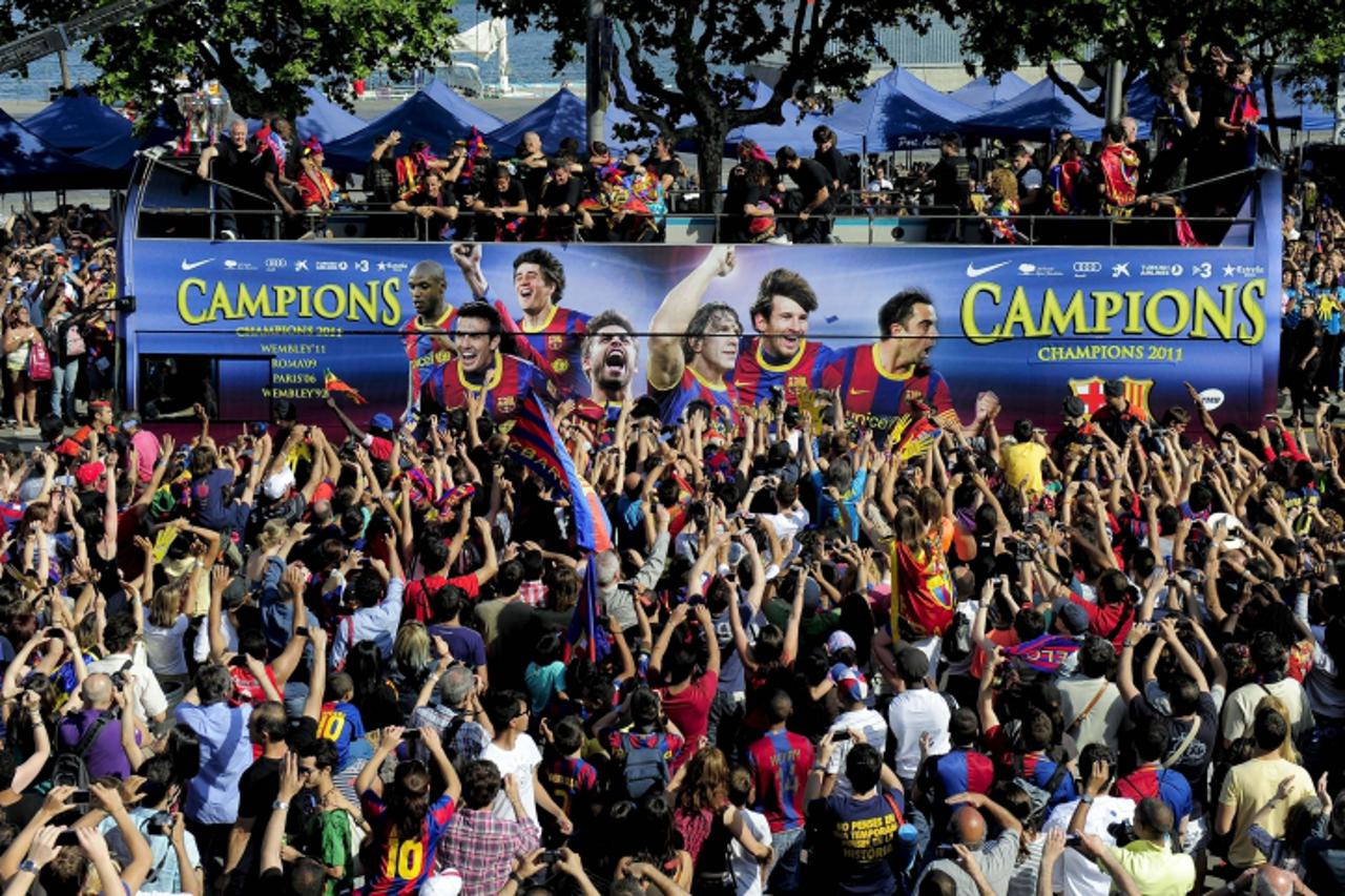 \'FC Barcelona\'s players celebrate in a bus carrying them through the streets of Barcelona on May 29, 2011 during a celebratory parade the day after they won the UEFA Champions League final football 