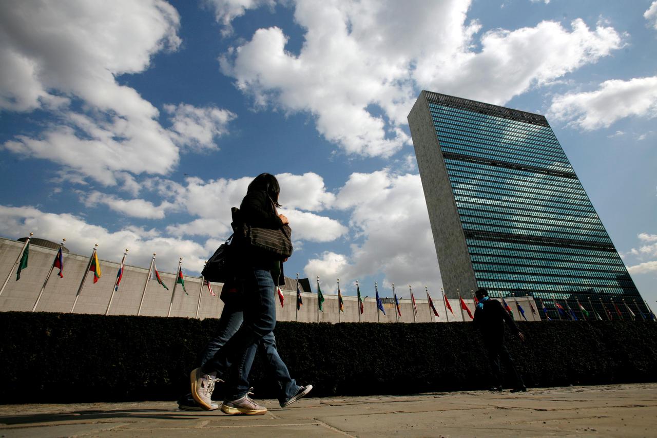 FILE PHOTO: Tourists pass United Nations Headquarters in New York