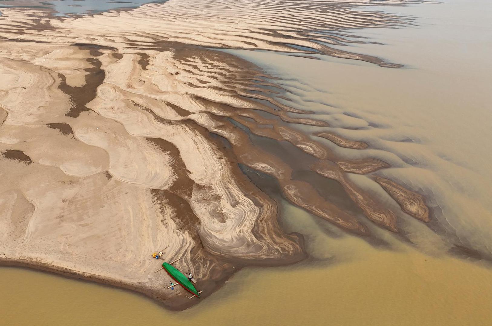 A drone view shows Reis Santo Vieira da Silva as a river dweller builds a canoe on the sandbanks of Madeira River during the worst drought of the river in history, in Humaita, Amazonas state, Brazil, September 7, 2024. REUTERS/Bruno Kelly Photo: BRUNO KELLY/REUTERS