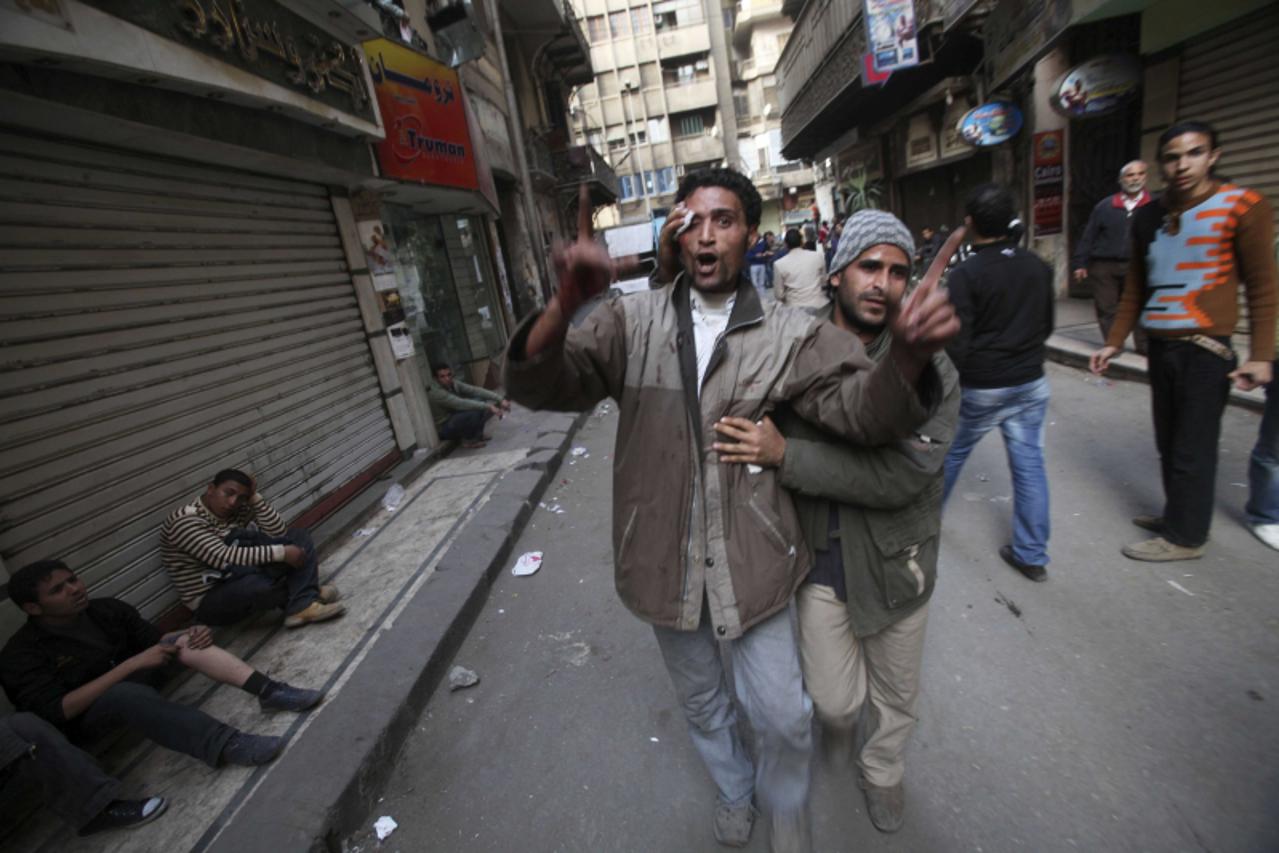 \'Injured demonstraters help each other during rioting between pro and anti-Mubarak supporters in Tahrir Square in Cairo February 2 , 2011. REUTERS/Suhaib Salem (EGYPT - Tags: POLITICS CIVIL UNREST)\'