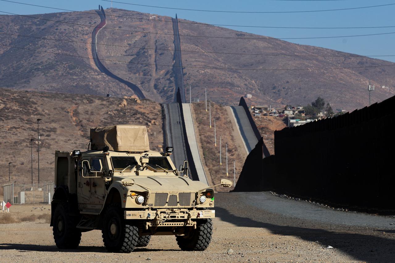 A California national guard vehicle stands near the wall on the United States and Mexico border in San Diego