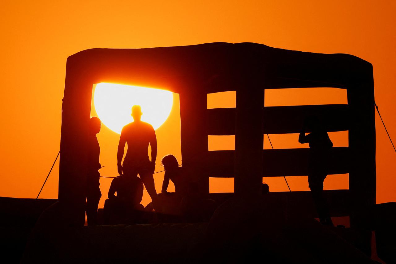 People relax at sunset as Malta braces for weekend heat
