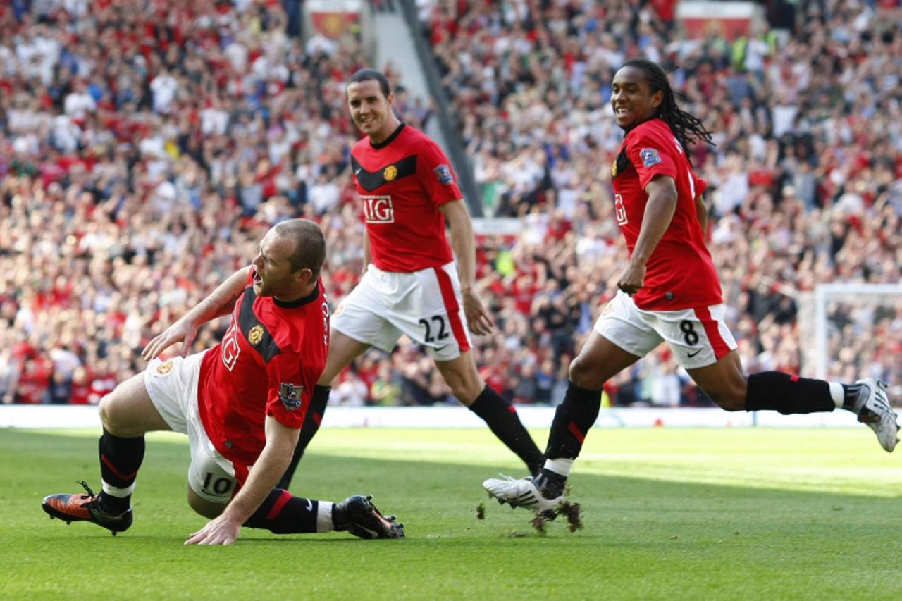 'Manchester United\'s Wayne Rooney (L) celebrates with Anderson (R) and John O\'Shea (C) after scoring during their English Premier League soccer match against Manchester City at Old Trafford in Manch