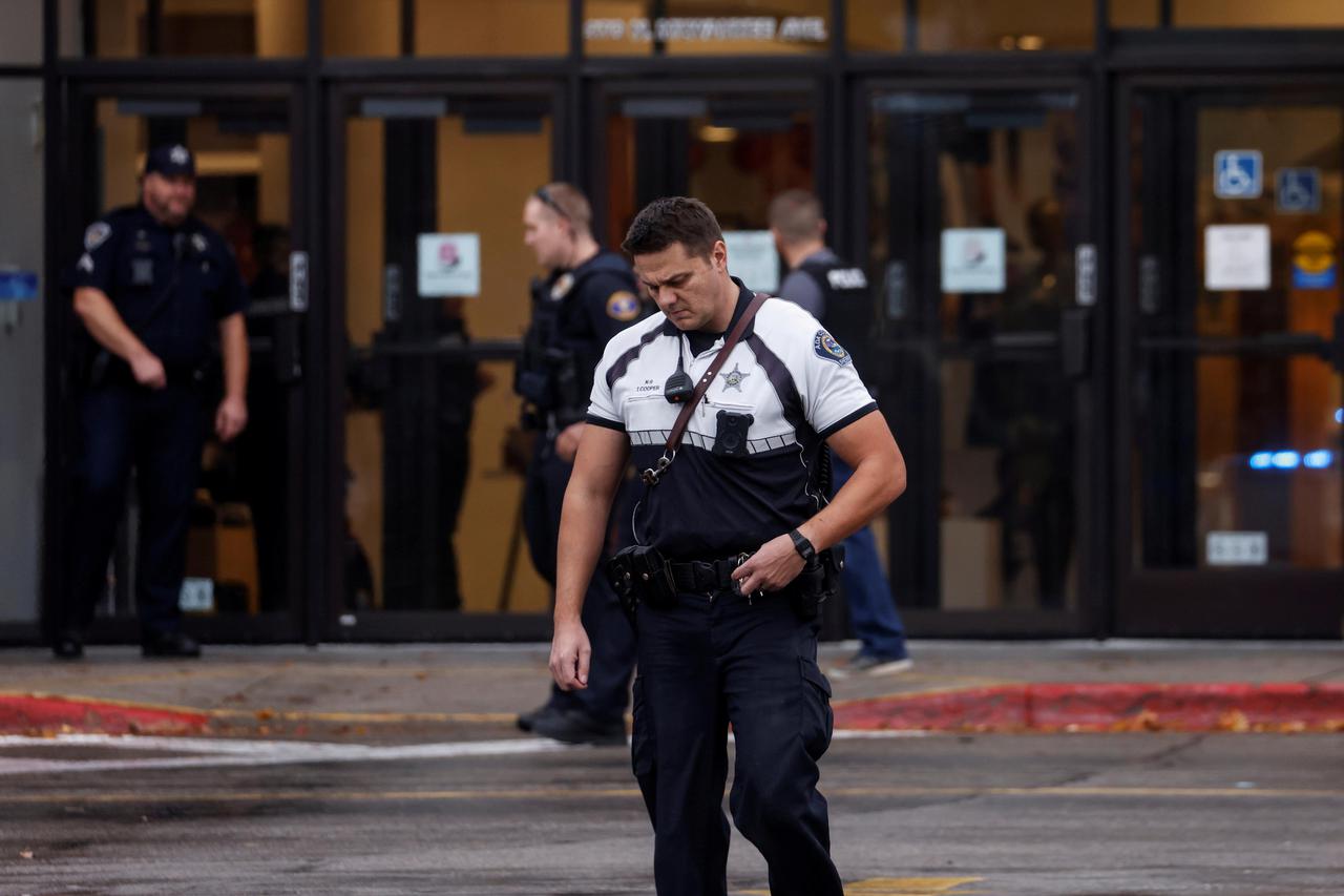 An officer from the Ada County Sheriff's Office walks from the scene of a shooting at the Boise Towne Square shopping mall in Boise, Idaho