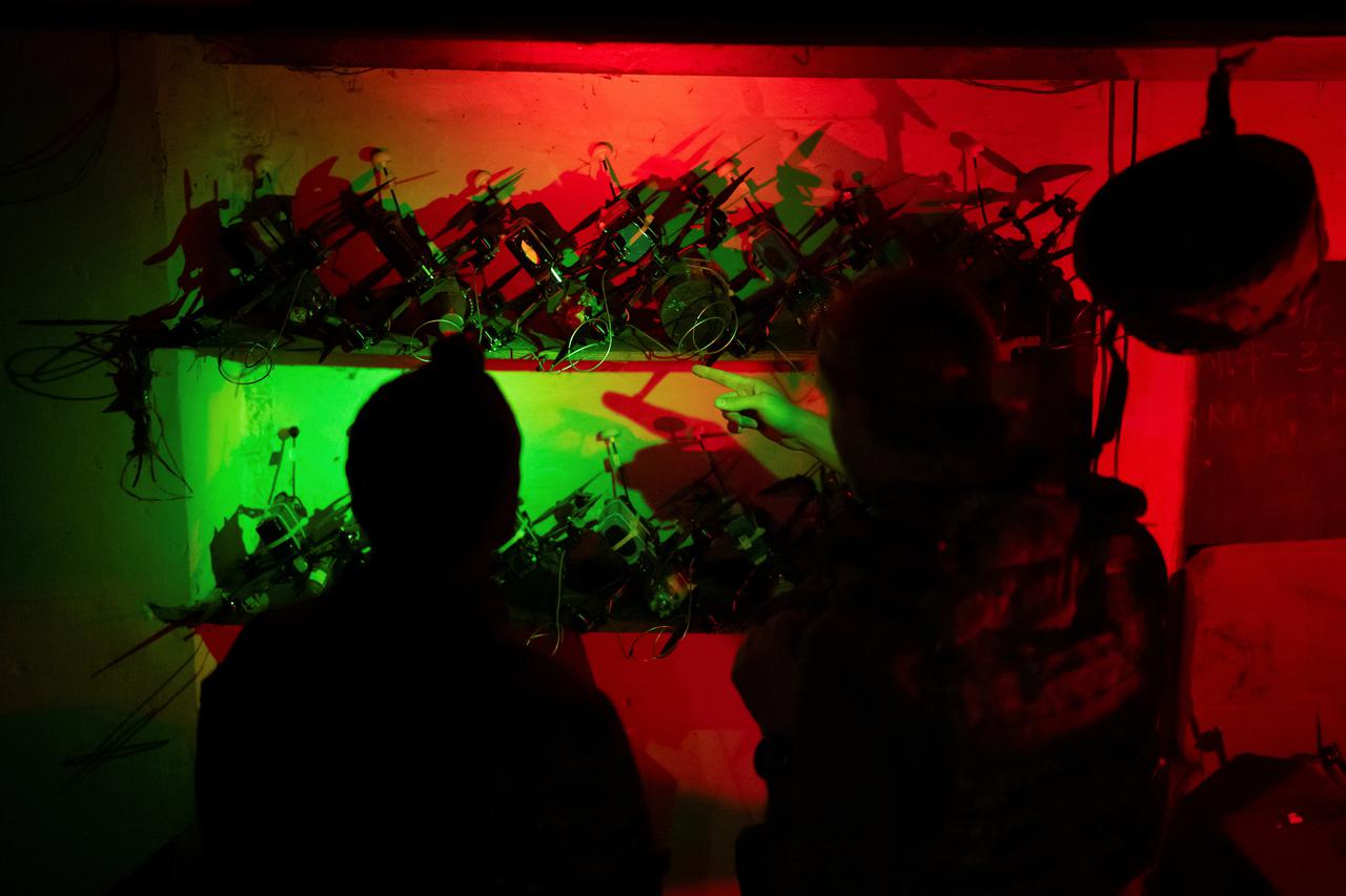 Ukrainian service members look at FPV-drones at their position near the front line town of Kupiansk