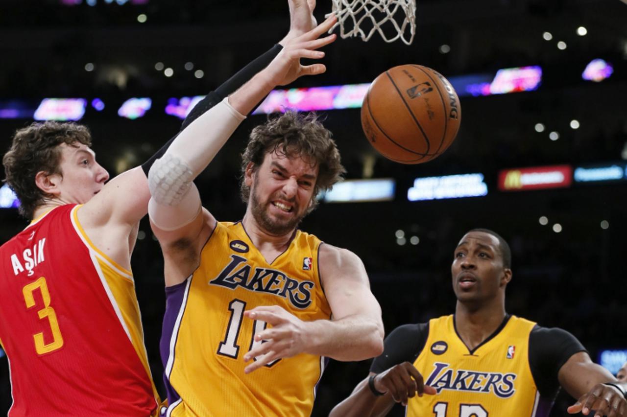 'Los Angeles Lakers Pau Gasol of Spain (C) is fouled by Houston Rockets Omer Asik of Turkey (L) as the Lakers Dwight Howard looks on during their NBA basketball game in Los Angeles April 17, 2013.  RE