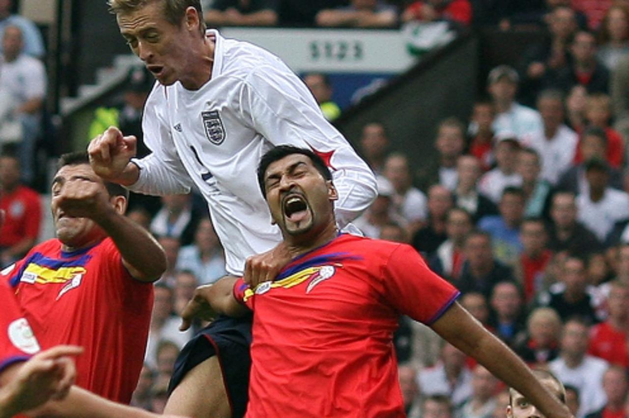 'England\'s Peter Crouch (C) rises above Oscar Sonejee to score his second goal during their Group E European Championship qualifying soccer match against Andorra at Old Trafford in Manchester, northe