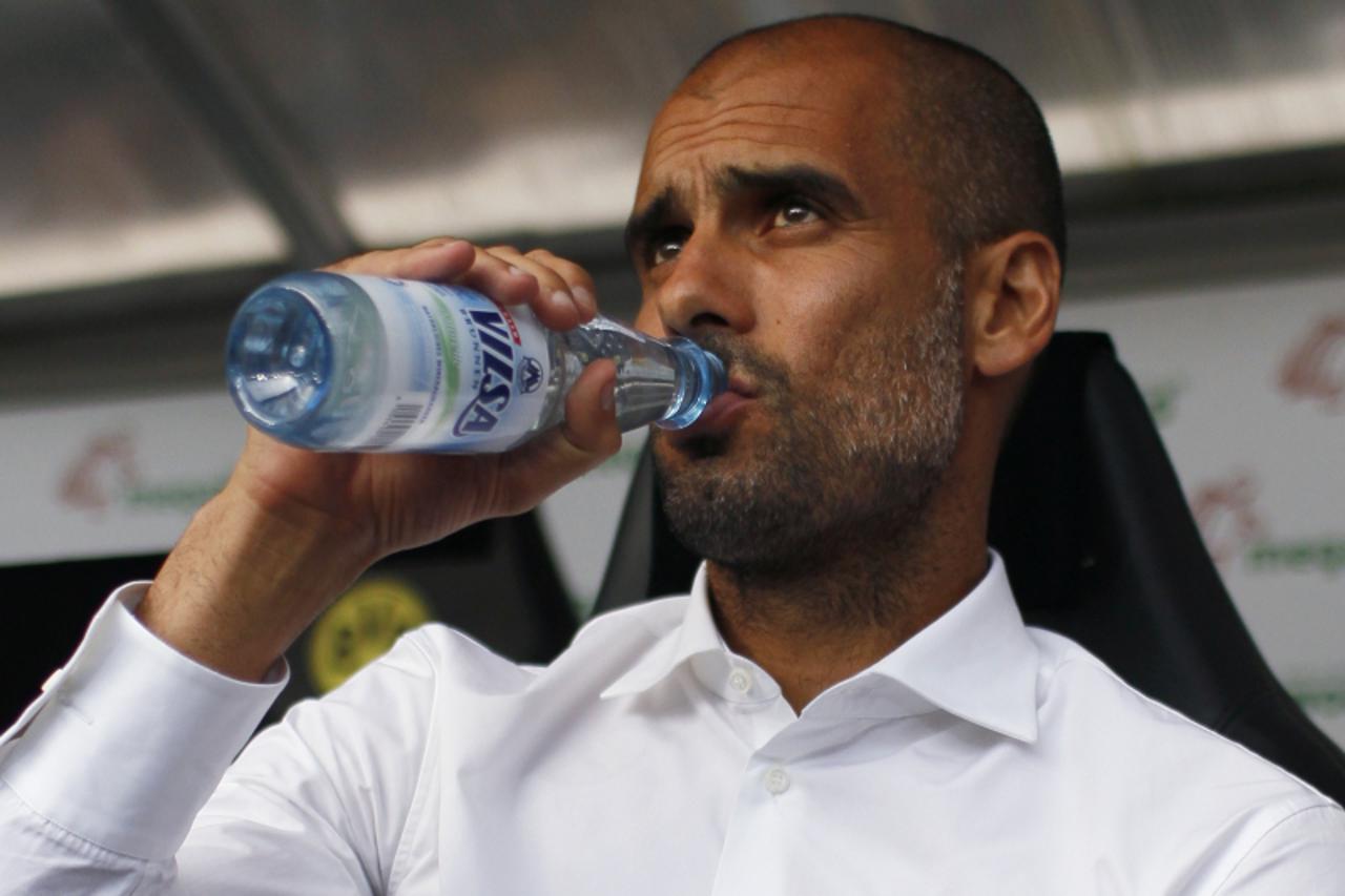 'Bayern Munich\'s Spanish coach Pep Guardiola drinks water before his team\'s SuperCup 2013 soccer match against Borussia Dortmund in Dortmund July 27, 2013. REUTERS/Wolfgang Rattay (GERMANY - Tags: S