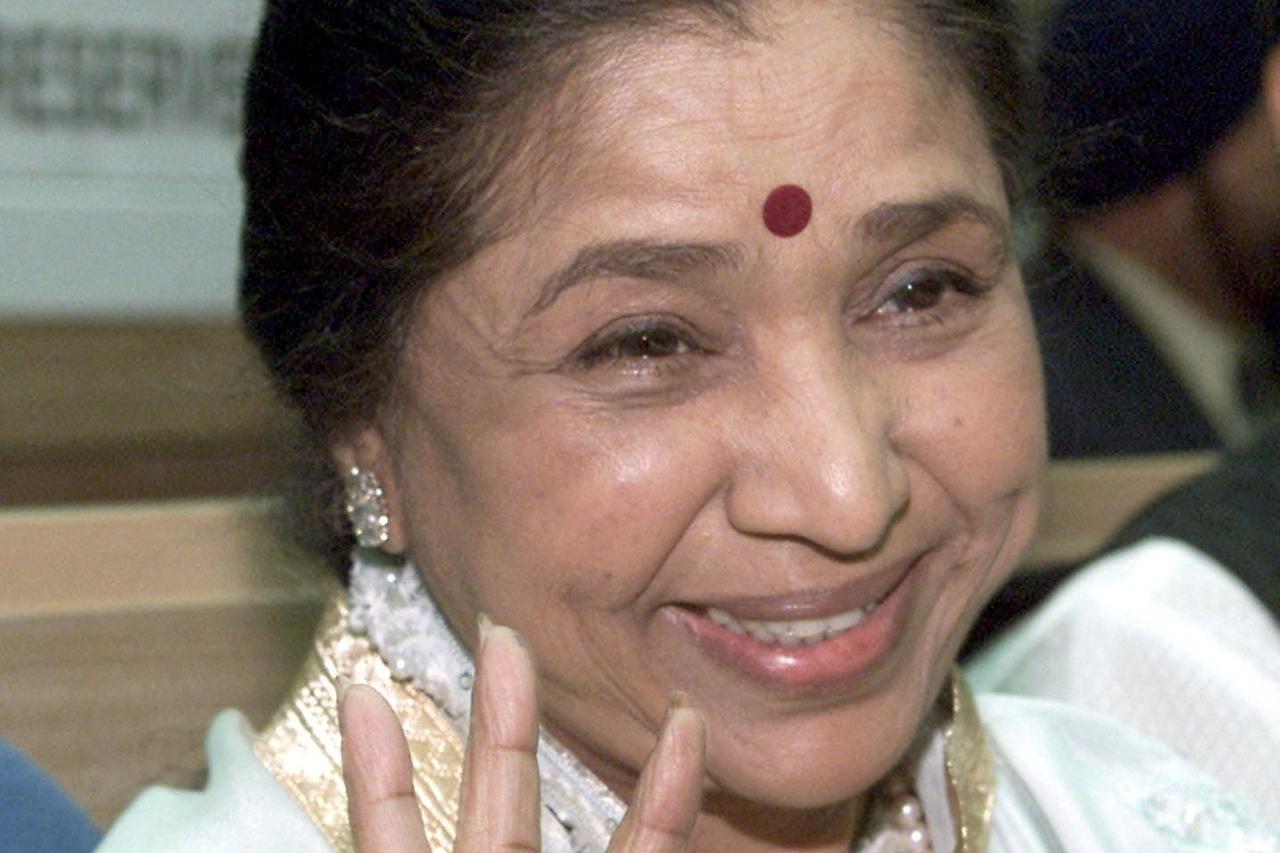 FILE PHOTO: Singer Asha Bhosle holds aloft a Dada Saheb Phalke award in New Delhi