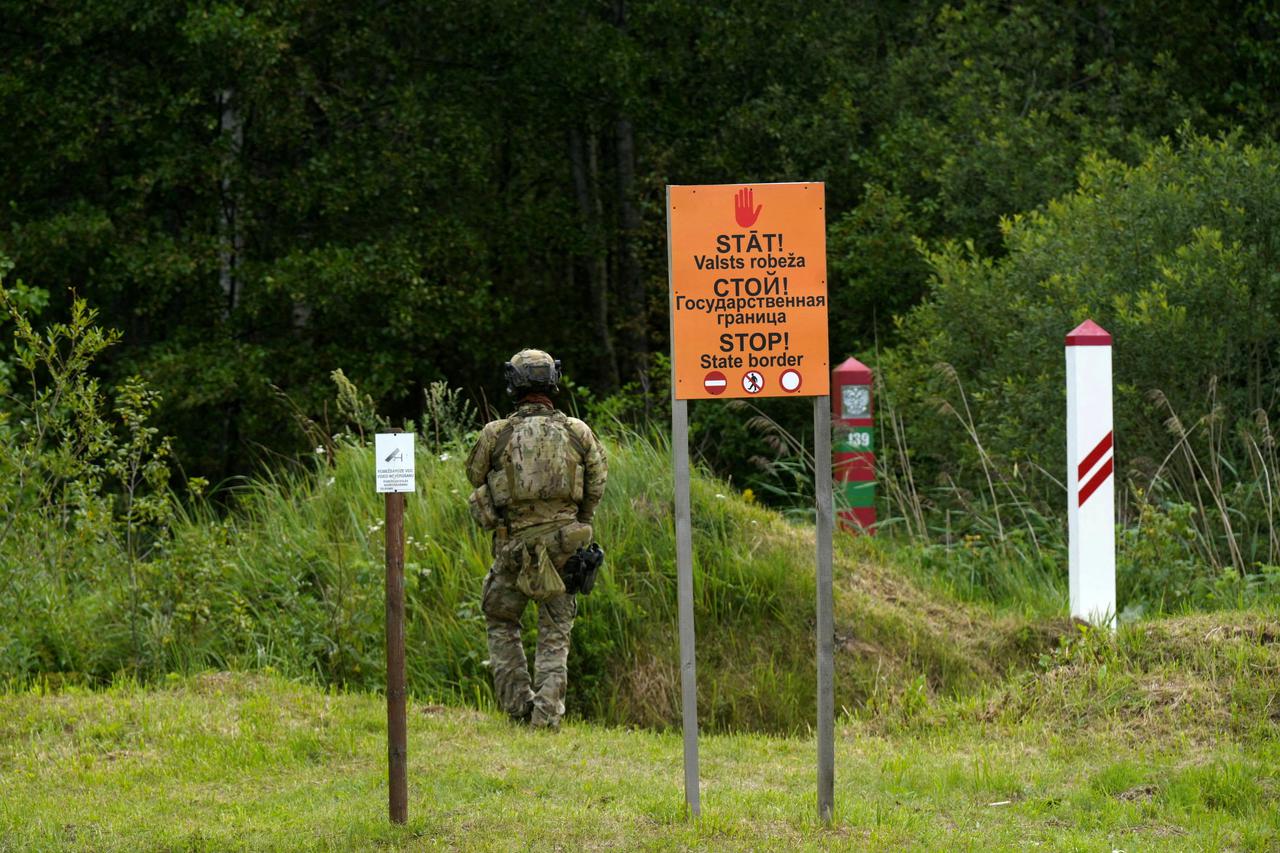 FILE PHOTO: Latvian and Russian border signs are seen at the Latvia-Russia border near Lidumnieki