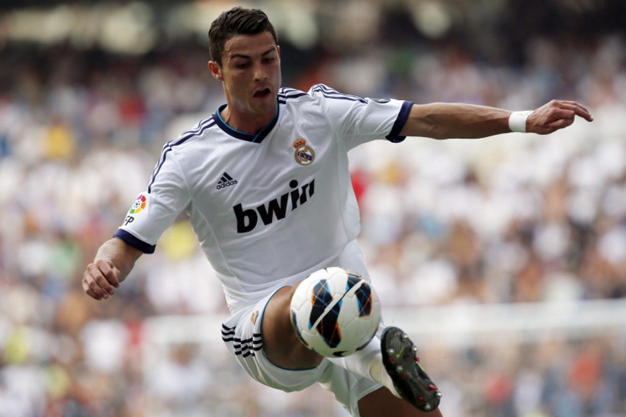 'Real Madrid's Cristiano Ronaldo controls the ball during their Spanish first division soccer match against Valencia at Santiago Bernabeu in Madrid August 19, 2012.  REUTERS/Sergio Perez  (SPAIN - Ta