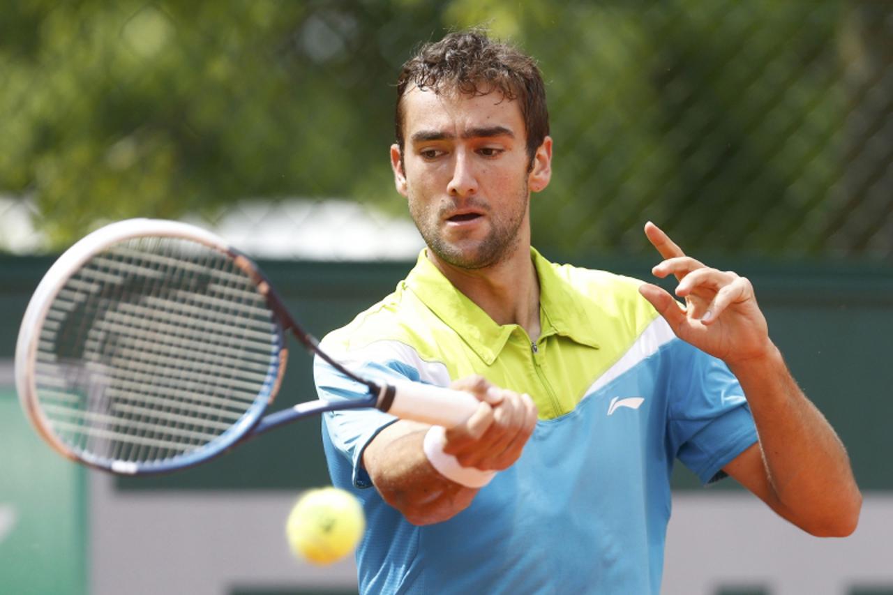 'Marin Cilic of Croatia hits a return to Nick Kyrgios of Australia during their men\'s singles match at the French Open tennis tournament at the Roland Garros stadium in Paris May 29, 2013. Cilic beat