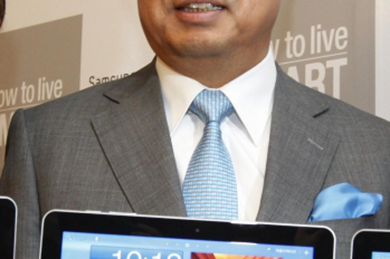 'JK Shin (C), president and head of Samsung\'s mobile division, holds Samsung Electronics\' new tablet \'Galaxy Tab 10.1\' as he poses for photographs during its launch ceremony at the company\'s head