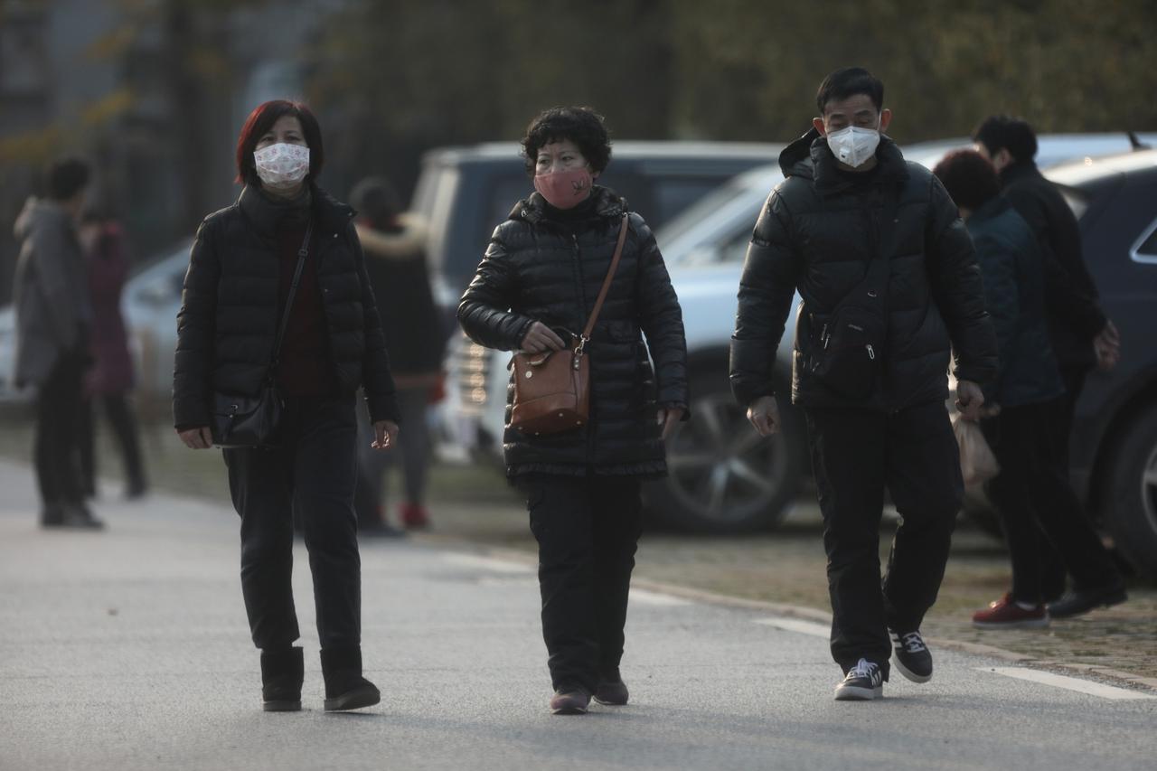 Ljudi s maskama ispred bolnice u kojoj se liječe oboljeli od novog virusa