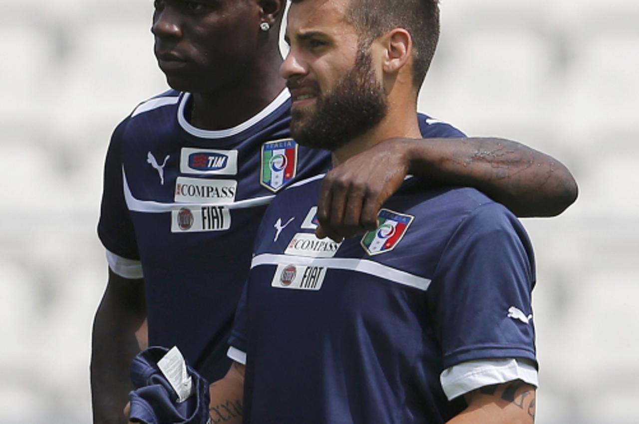 'Italy\'s soccer players Mario Balotelli (L) and Antonio Nocerino rest during a training session for the Euro 2012 at Cracovia Stadium in Krakow June 08, 2012.  REUTERS/Tony Gentile (POLAND  - Tags: S