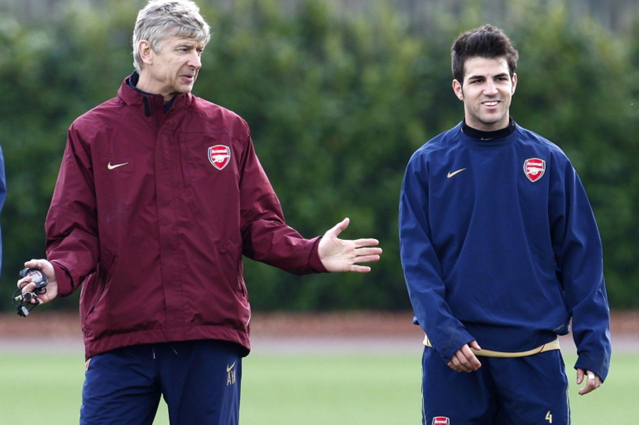 'Arsenal manager Arsene Wenger (L) talks to Cesc Fabregas during a team training session in London Colney, north of London April 1, 2008. Arsenal are due to play Liverpool in the first leg of a Champi