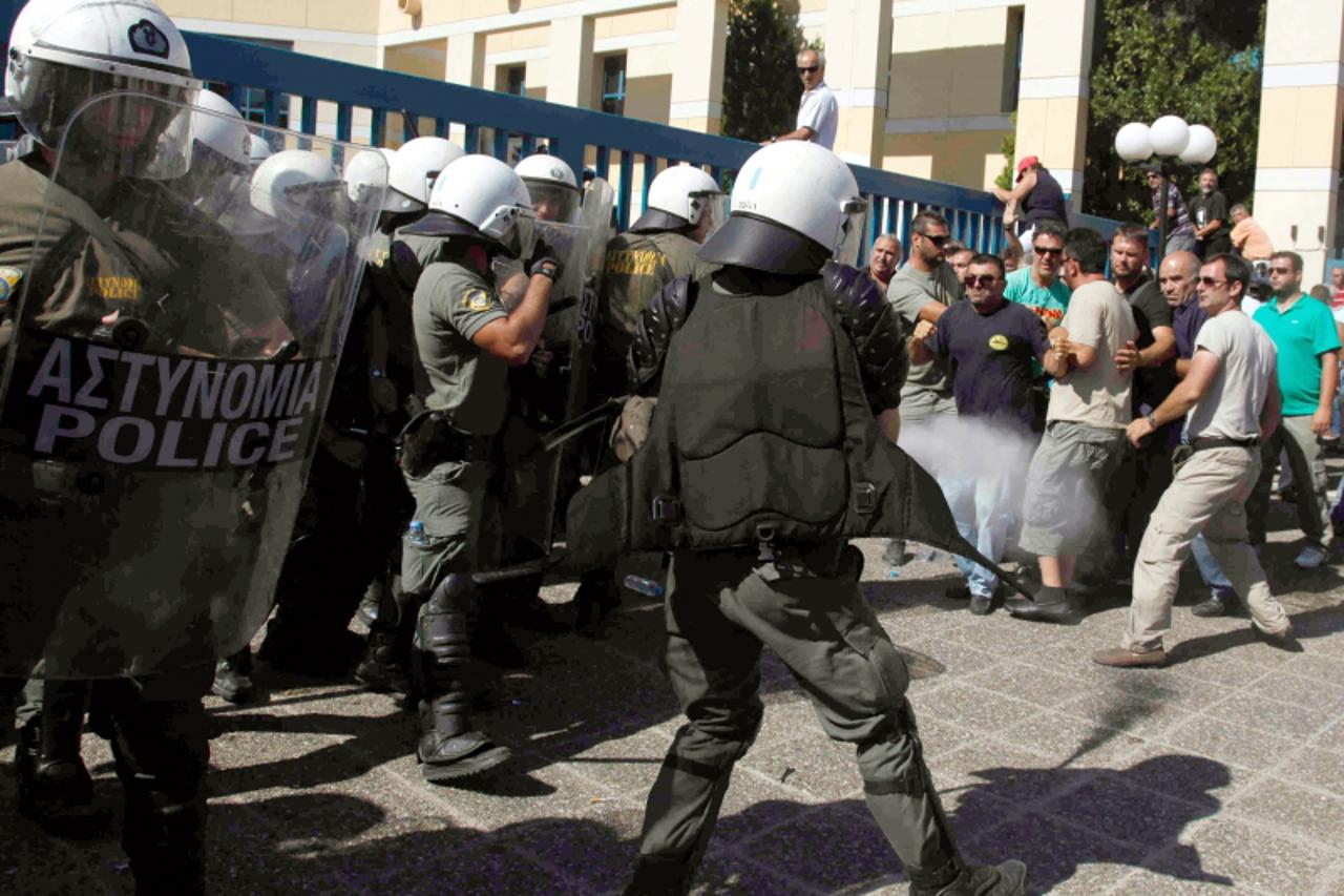 'Striking Greek truckers clash with riot police during a protest in front of the transport ministry in Athens after the government ordered them back to work on July 29, 2010. Police used tear gas to d