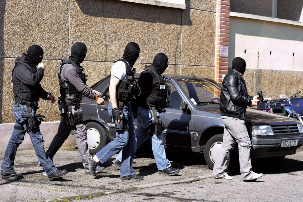 'Hooded policemen walk next to the building where self-professed Al-Qaeda militant Mohamed Merah, 23, was living on March 23, 2012  in Toulouse, southwestern France. French police today prolonged the 
