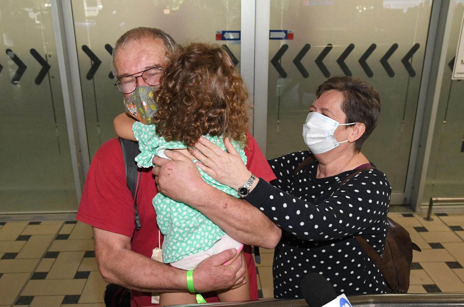 Rudolf and Julianna Nemeth from Hungary reunite with their granddaughter Lili as they arrive on the first international flight to the Brisbane International Airport, after Australia reopened its international borders to travelers vaccinated against the coronavirus disease (COVID-19), in Brisbane, Australia February 21, 2022. AAP Image/Darren England via REUTERS ATTENTION EDITORS - THIS IMAGE WAS PROVIDED BY A THIRD PARTY. NO RESALES. NO ARCHIVE. AUSTRALIA OUT. NEW ZEALAND OUT. Photo: Stringer/REUTERS