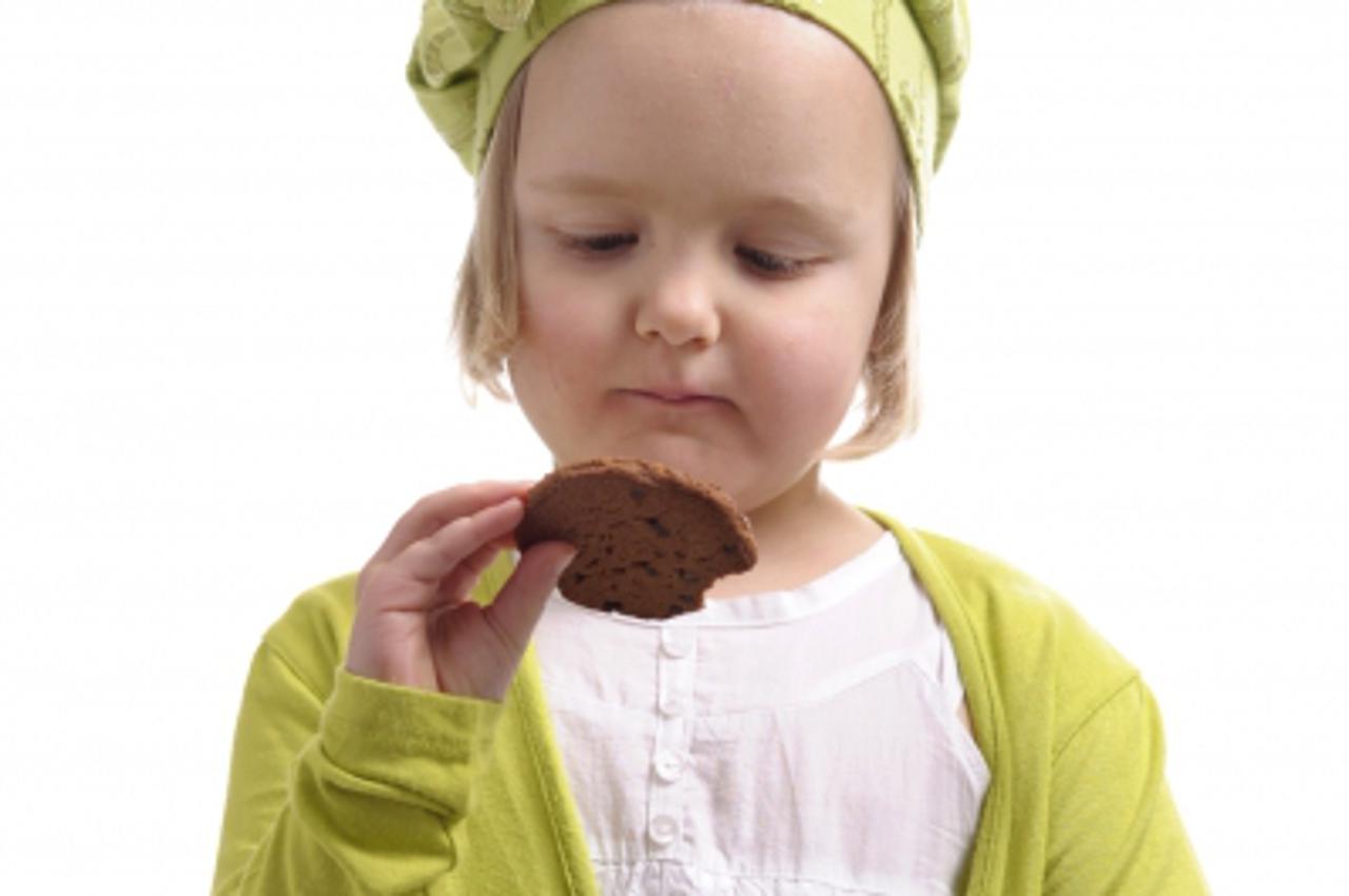 'little girl eating a cookie'