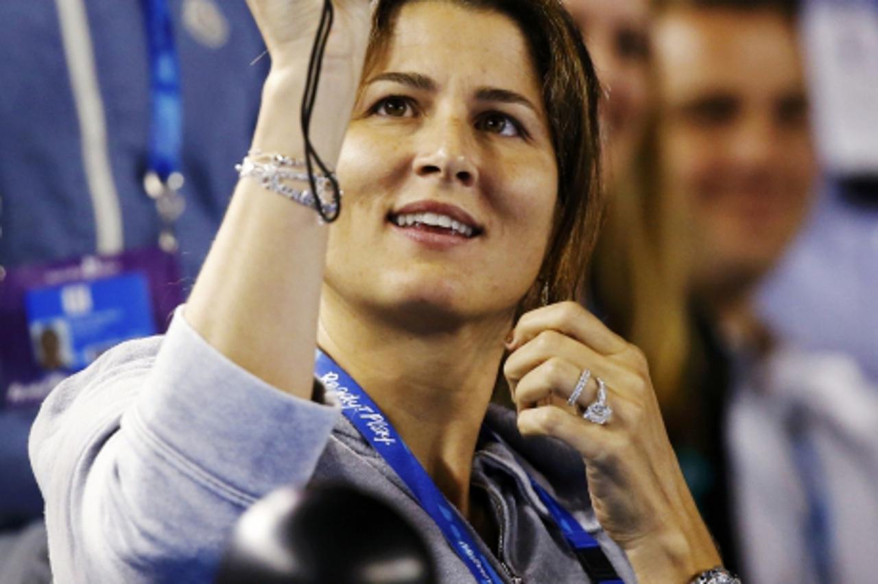 'Mirka Federer, wife of Roger Federer of Switzerland, takes pictures with her camera during his men\'s singles match against Bernard Tomic of Australia at the Australian Open tennis tournament in Melb