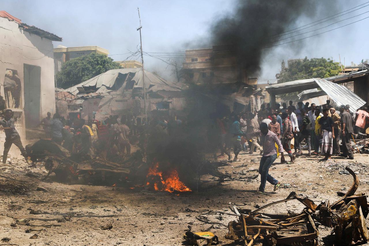 Civilians attempt to extinguish the fire at the scene of an explosion in the Hamarweyne district of Mogadishu
