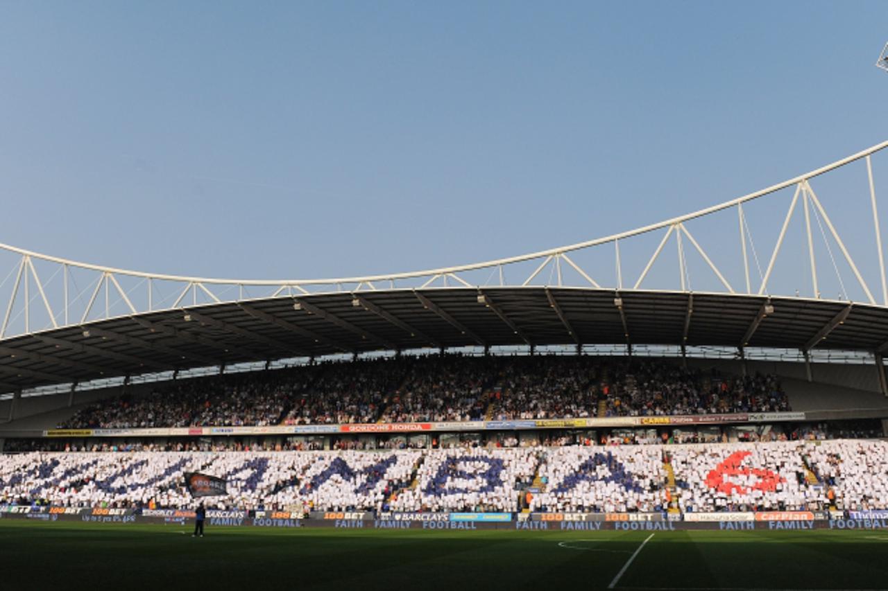 'Fans hold up cards spelling the name Muamba, as a means of wishing cardiac arrest victim and player Fabrice Muamba well before the English Premier League football match between Bolton and Blackburn R