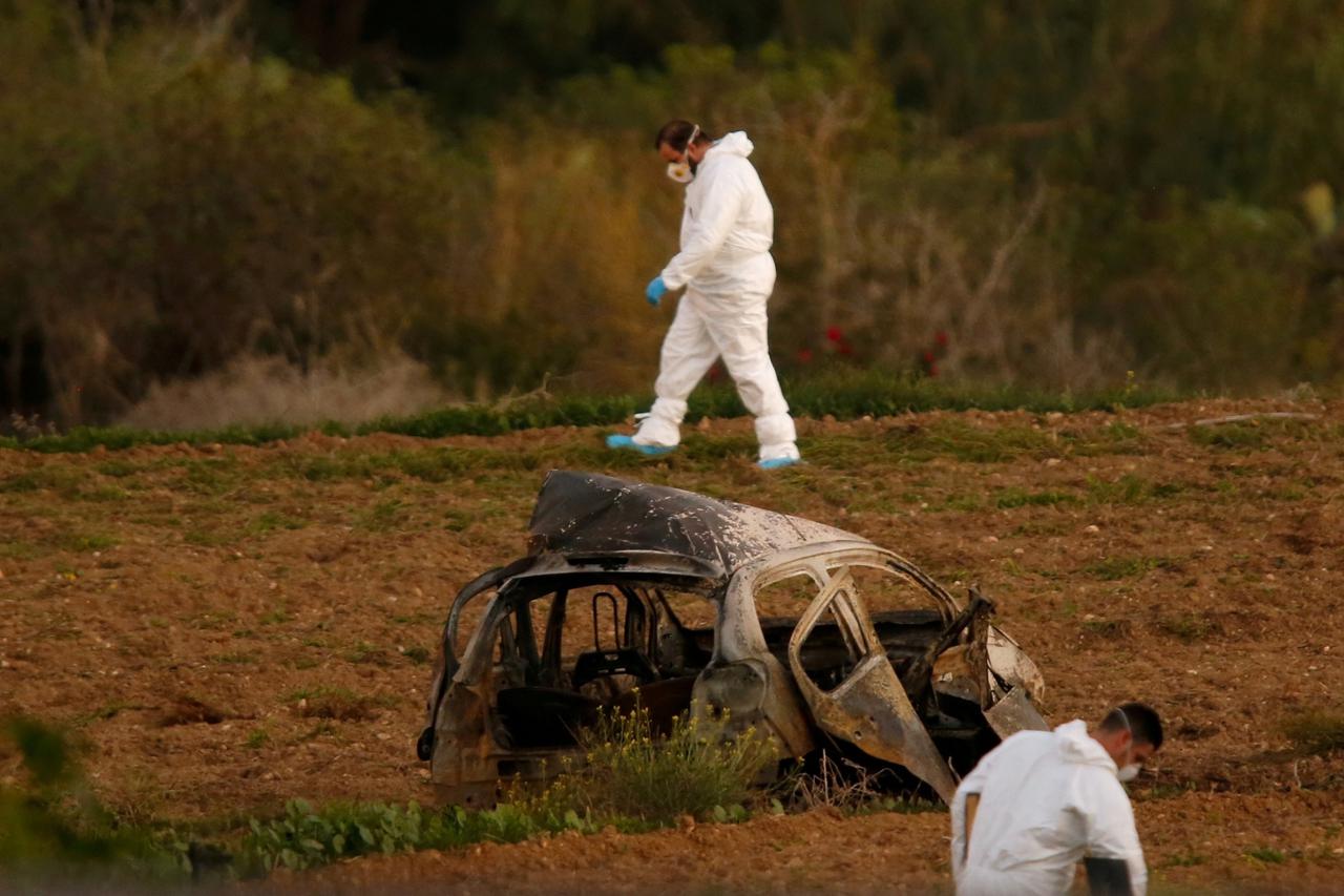 FILE PHOTO: Forensic experts walk in a field after a powerful bomb blew up a car killing investigative journalist Daphne Caruana Galizia in Bidnija