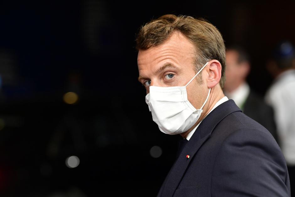French President Emmanuel Macron leaves after a meeting of an EU summit on a coronavirus recovery package at the European Council building in Brussels
