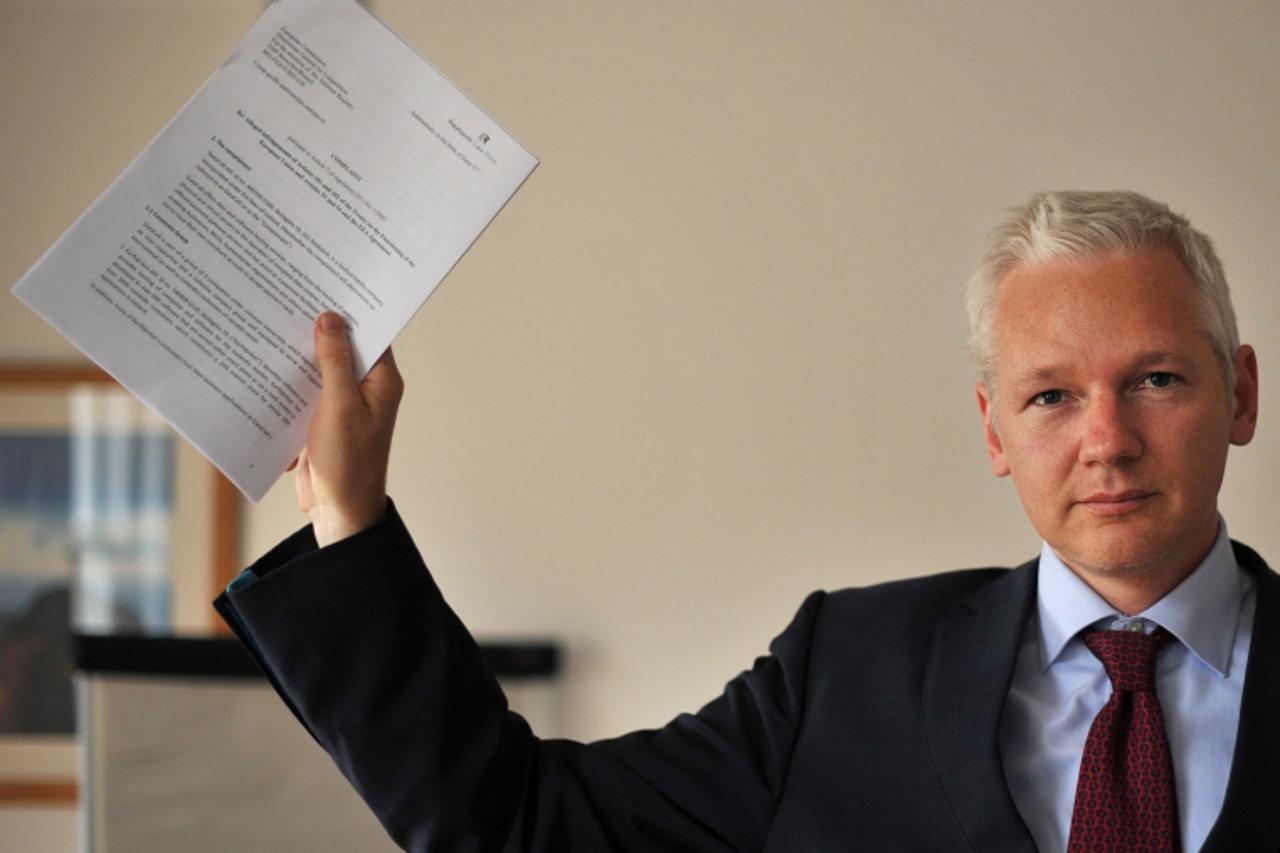 'Wikileaks founder Julian Assange holds a legal document as he addresses a press conference in central London, on July 14, 2011. Assange discussed Wikileaks\' relationship with Visa Europe and Masterc