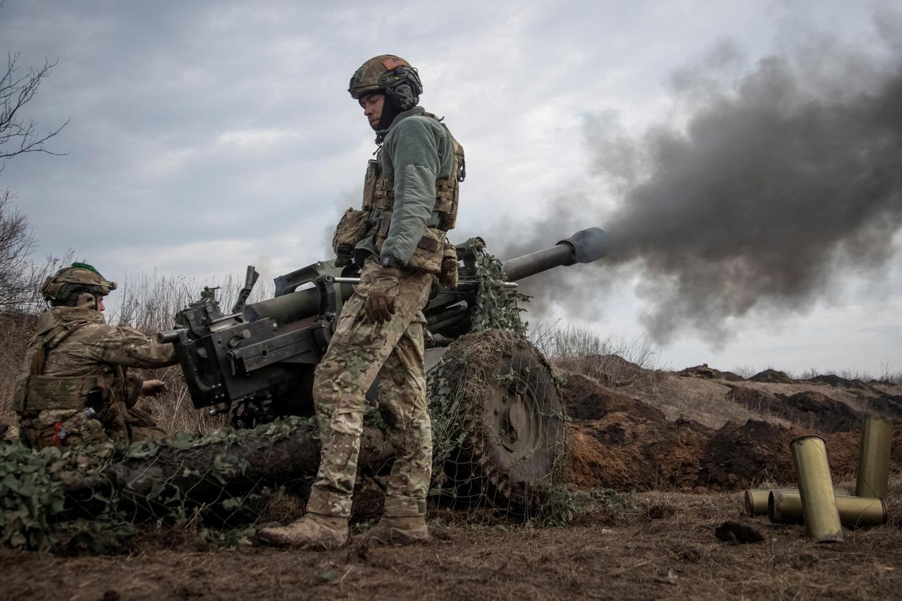 FILE PHOTO: Ukrainian service members fire a howitzer M119 at a front line near Bakhmut