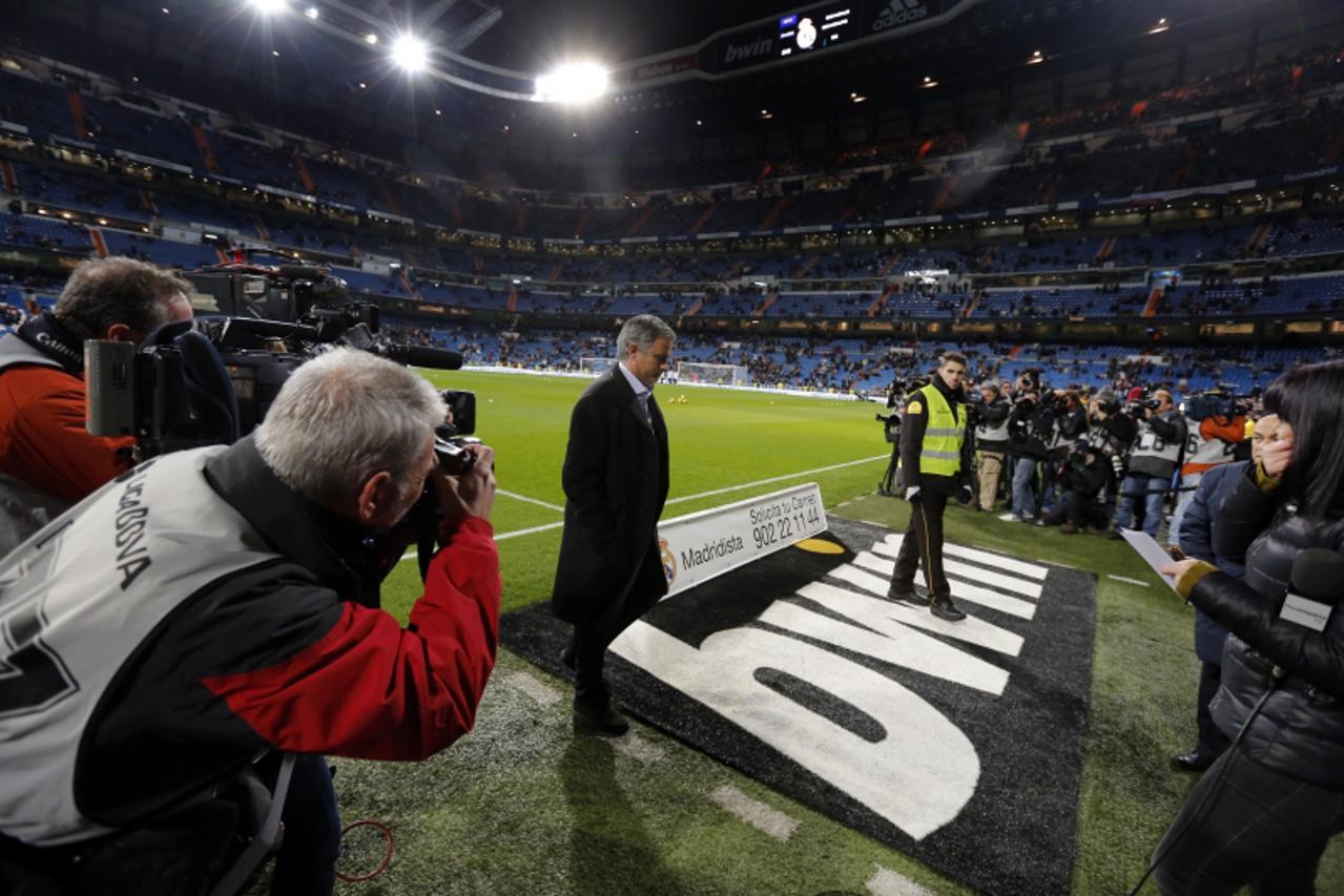 'Real Madrid\'s Portuguese coach Jose Mourinho walks on the pitch before the Spanish league football match Real Madrid CF vs Atletico Madrid at the Santiago Bernabeu stadium in Madrid on December 1, 2