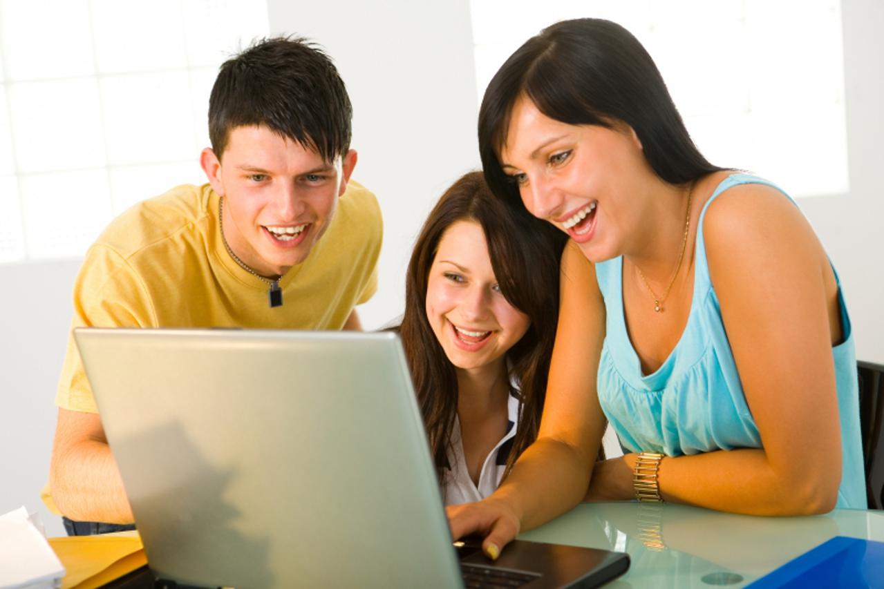'Smiling students with laptop computer'