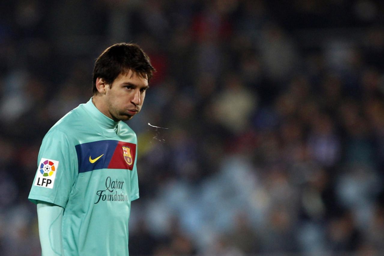'Barcelona\'s Lionel Messi spits during their Spanish First Division soccer match against Getafe at Colisseum Alfonso Perez stadium in Getafe November 26, 2011. REUTERS/Susana Vera (SPAIN - Tags: SPOR
