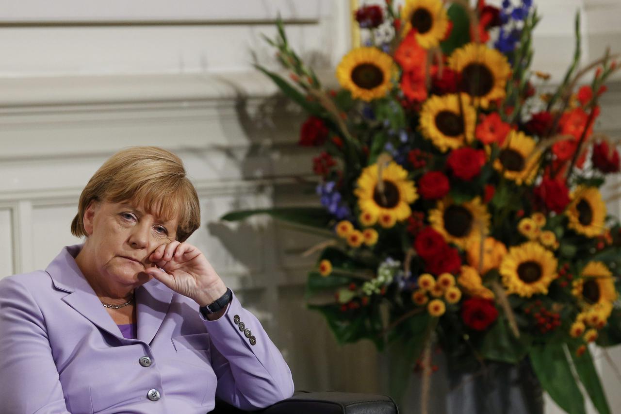 German Chancellor Angela Merkel is listening to her laudation during the award ceremony for her Doctor Honoris Causa, or honorary doctorate, by Bern University rector Martin Taeuber (R) in Bern, Switzerland September 3, 2015.  REUTERS/Denis Balibouse     