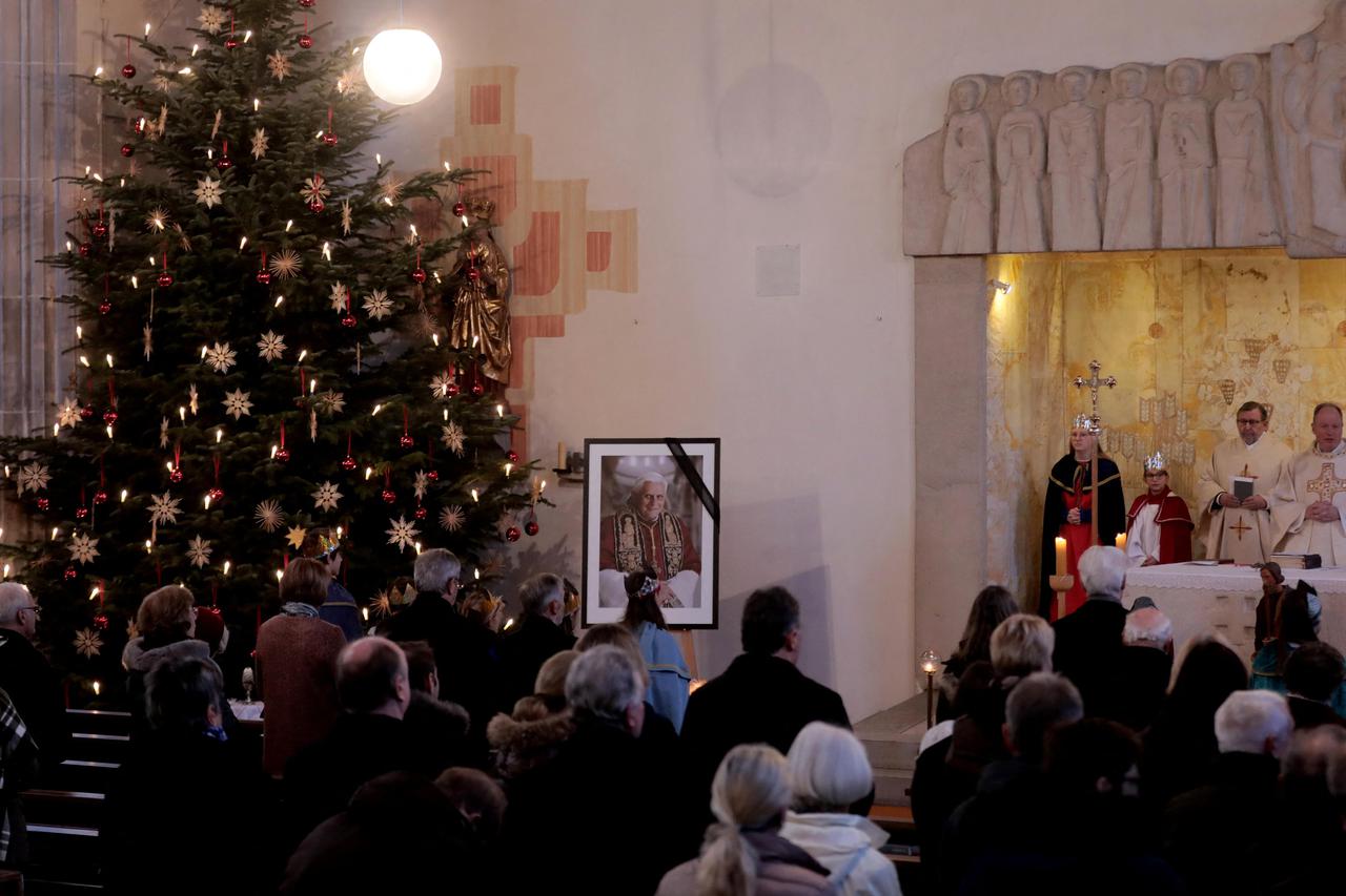 People take part in a church service at St. Oswald Church in Marktl