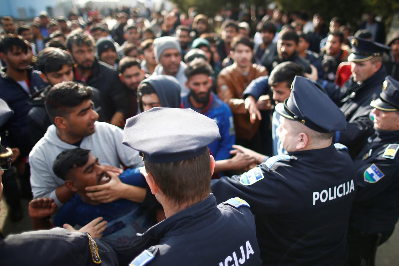 Migrants scuffle with police as they try to block a road in front of the refugee camp Miral in Velika Kladusa