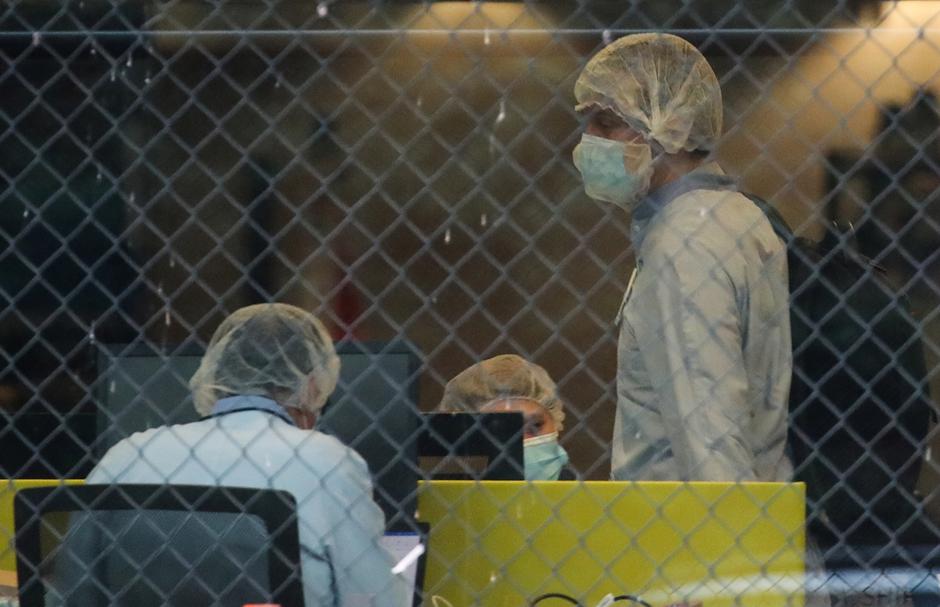 People wearing protective face masks are seen inside the Pfizer plant in Puurs