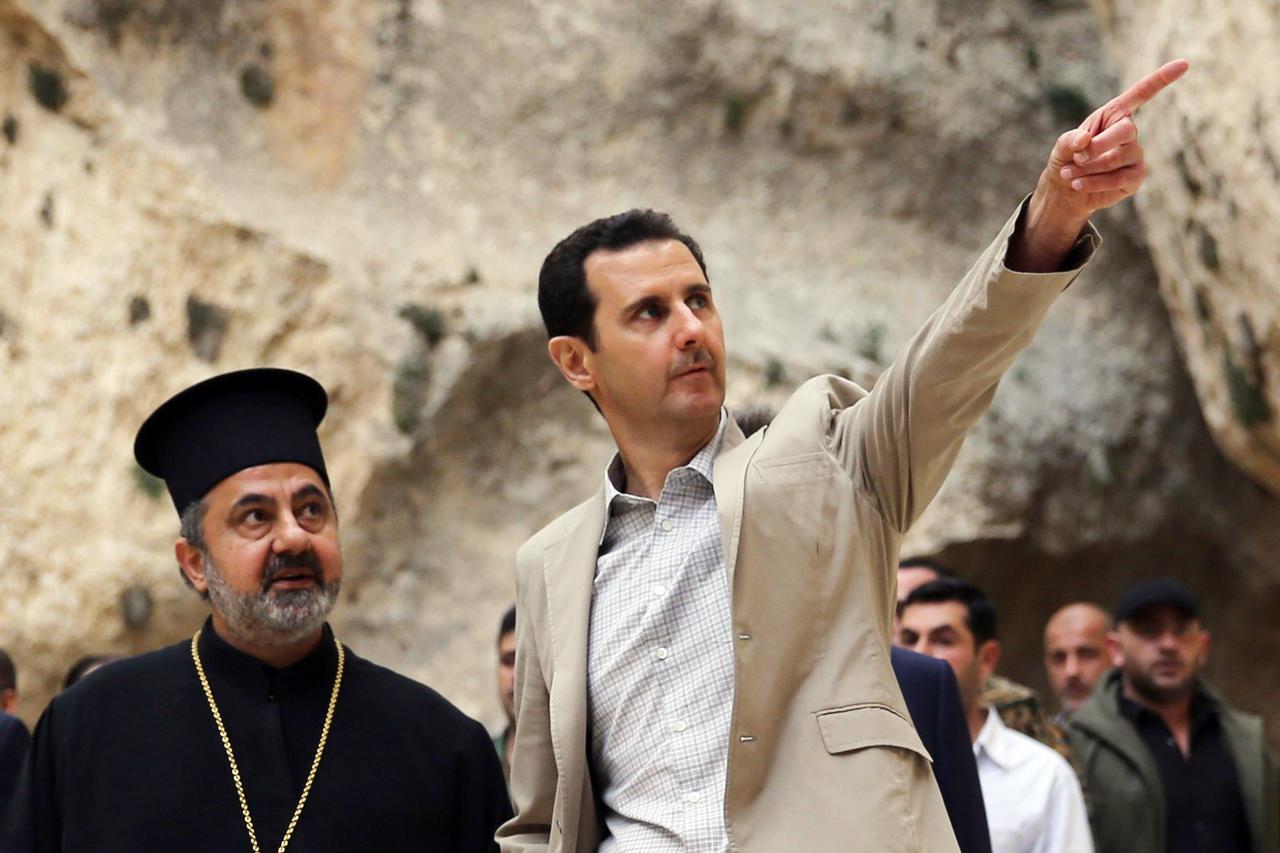 A handout picture taken on April 20, 2014 by the official Syrian Arab News Agency (SANA) shows Syria's President Bashar al-Assad (C) visiting the ancient Christian town of Maalula which his troops recently recaptured from rebels.  AFP PHOTO /HO/SANA  === 