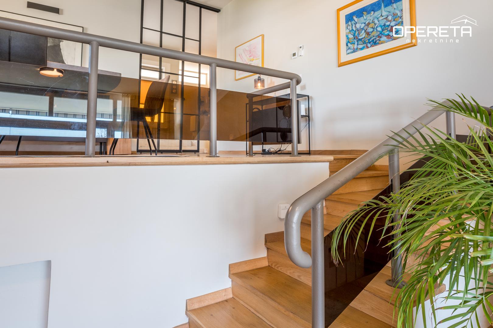 Ima dnevni boravak s kaminom i blagovaonicom, opremljenu kuhinju te pomoćnu kuhinju, tri spavaće sobe, dvije kupaonice, dodatni WC, spremište i veliku garažu