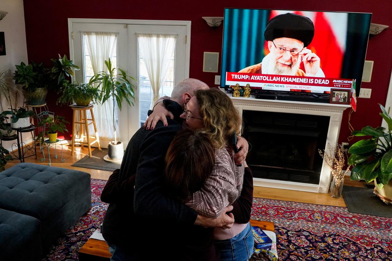 Iranian American community member watch a TV screen broadcasting news, on the day the United States and Israel launched strikes on Iran, in Vienna