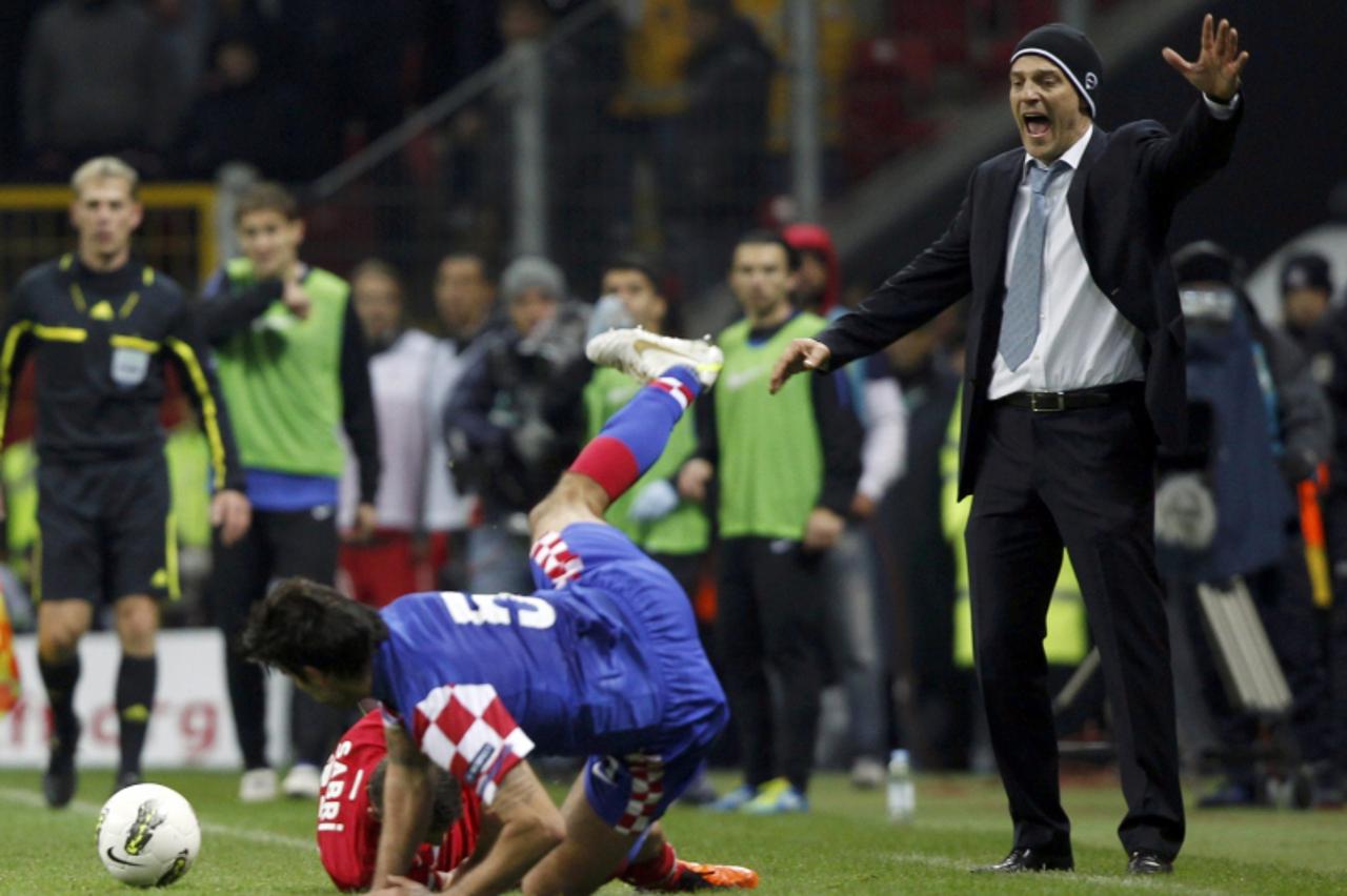 'Croatia\'s coach Slaven Bilic (R) reacts as Turkey\'s Sabri Sarioglu (bottom) fouls Vedran Corluka (C) during the first leg of their Euro 2012 play-off soccer match at Turk Telekom Arena in Istanbul 