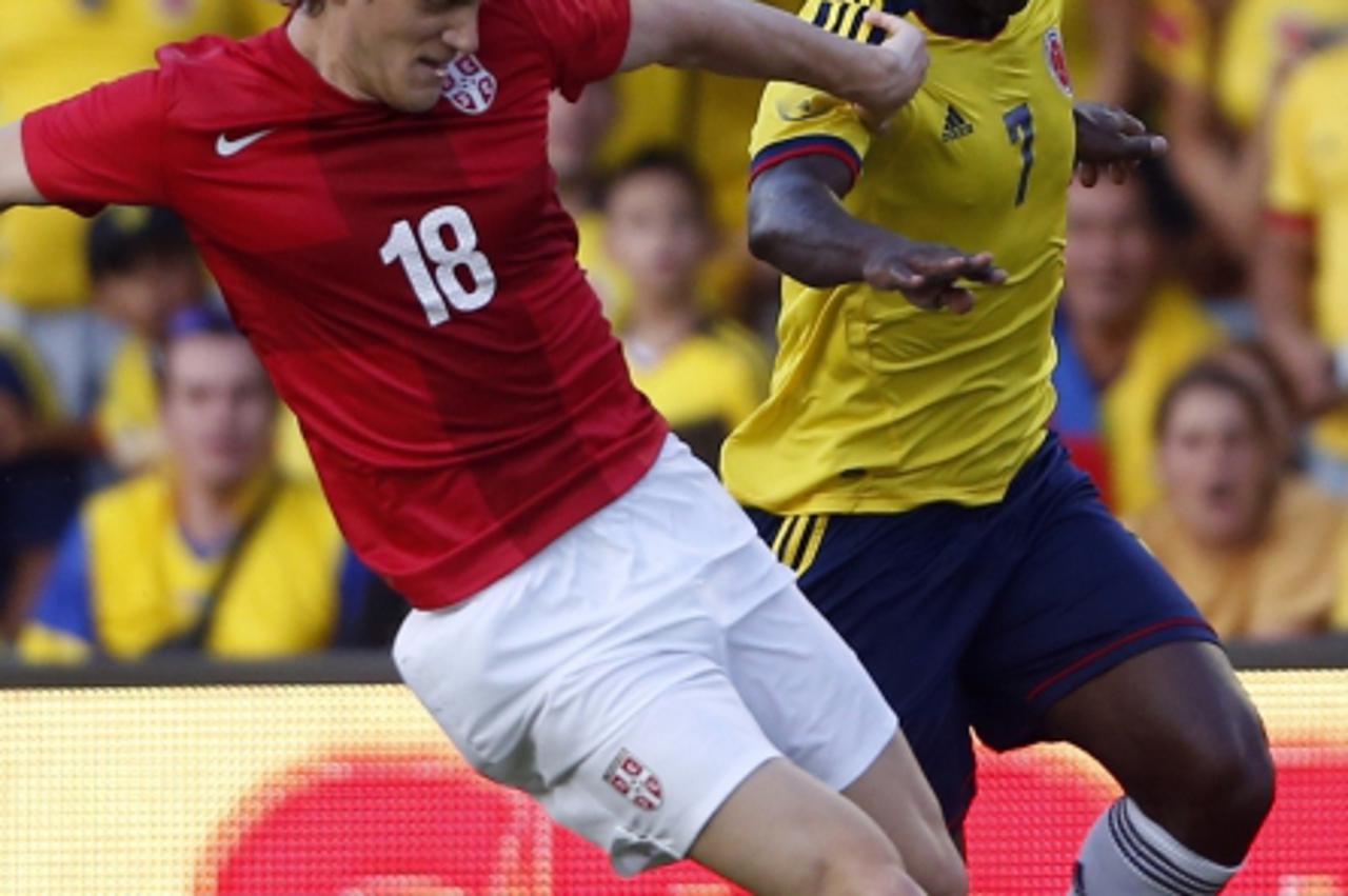 'Colombia's Pablo Armero (R) fights for the ball against Serbia's Dusan Basta during a international friendly soccer match at Mini-Estadi stadium in Barcelona August 14, 2013. REUTERS/Albert Gea (SP