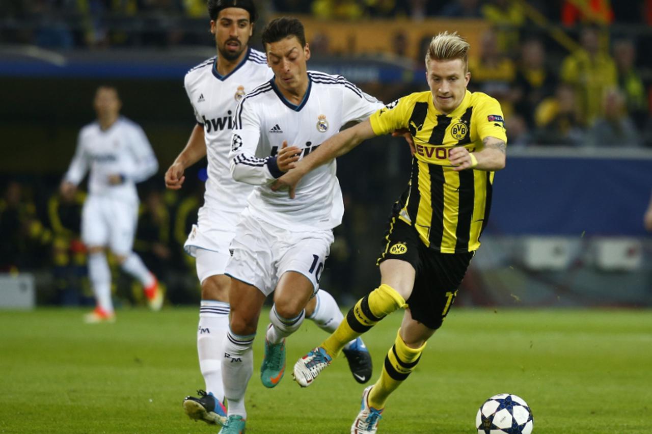 'Real Madrid's Sami Khedira  and Mesut Oezil (C) challenge Marco Reus (R) during their Champions League semi-final first leg soccer match at BVB stadium in Dortmund April 24, 2013.  (GERMANY) REUTERS