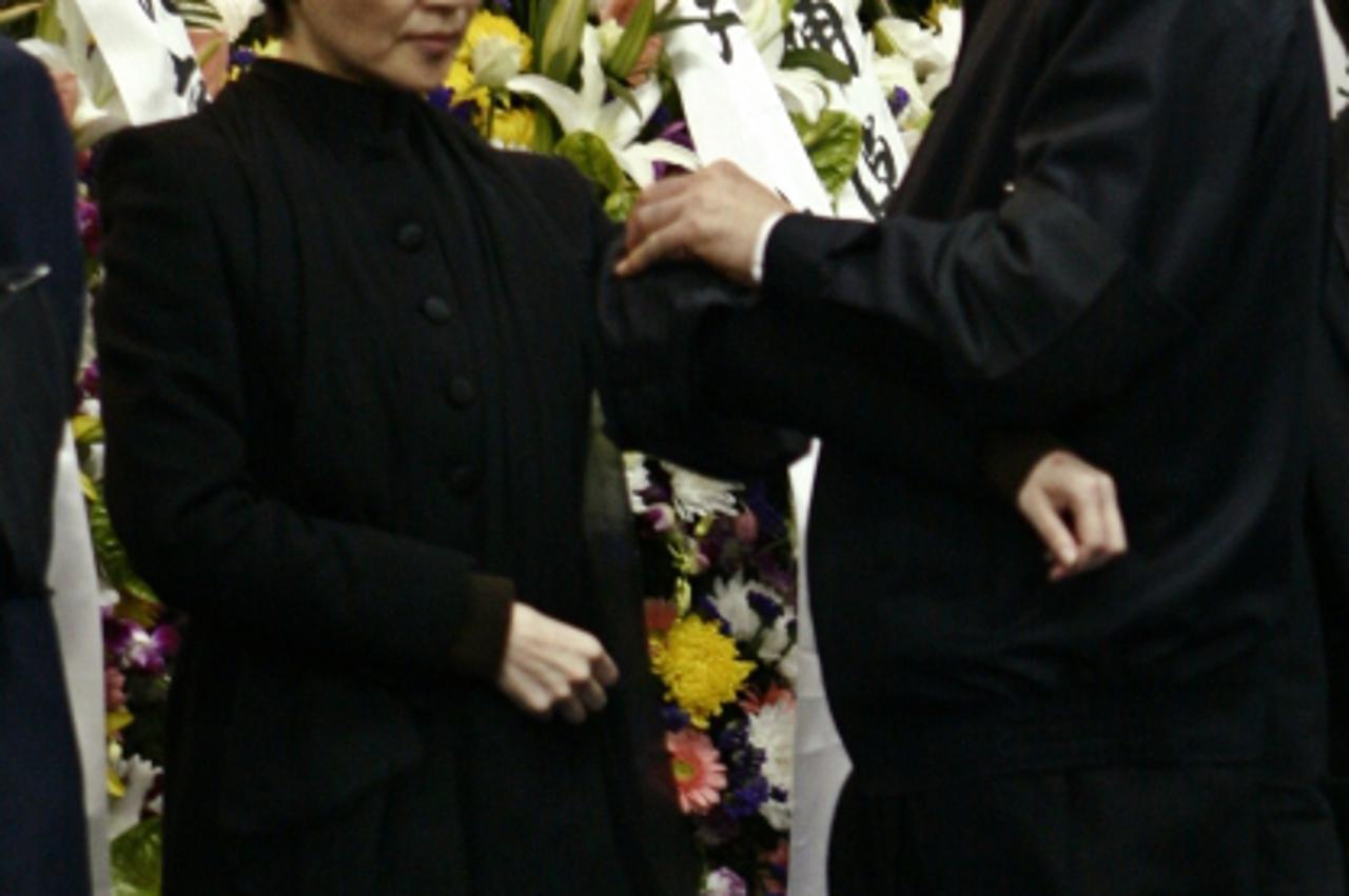 'China\'s former Chongqing Municipality Communist Party Secretary Bo Xilai (R) pins a piece of black cloth on the jacket of his wife Gu Kailai at a mourning held for his father Bo Yibo, former vice-ch