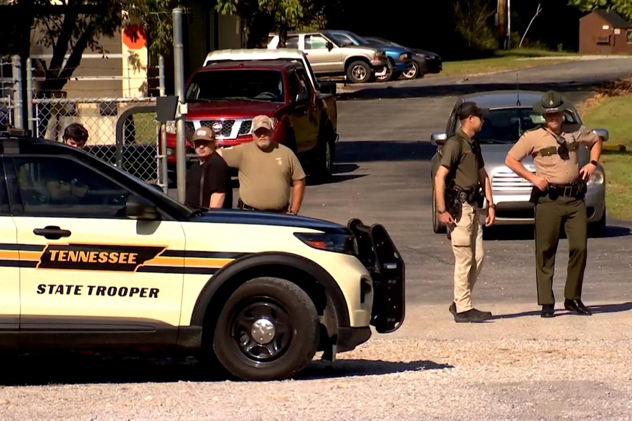 Law enforcement officers guard a gate outside the Accurate Energetic Systems military explosives plant in Bucksnort